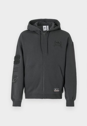Siva zip-up dukserica napravljena od mekanog materijala. Ima kapuljaču, rebraste manžete i dva otisnuta loga na prsima i rukavu. Dizajn redovne kroja.