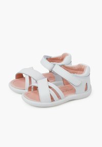 Sandalias de imitación de cuero blancas con forro interior rosa, diseño de punta abierta, correas ajustables de Velcro y suelas de goma texturizadas.