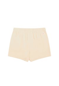 Jasnobeżowe spodenki wykonane z miękkiego materiału, z elastycznym paskiem w talii i małym logo na dolnej lewej stronie. Czysty, prosty design.