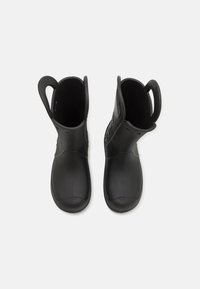 Para czarnych gumowych kaloszy z szerokimi uchwytami u góry, ułatwiającymi zakładanie, pokazana z góry na białym tle.