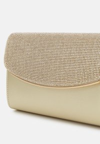 Clutch dorato con parte anteriore testurizzata ricoperta da piccole perline metalliche. Sides lisci e curvi con una chiusura a pattina e una sottile rifinitura dorata.