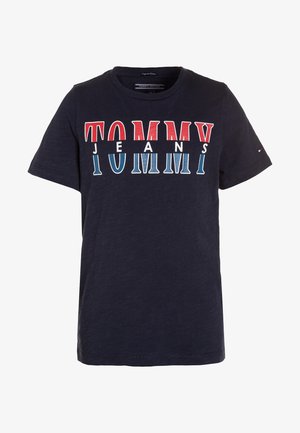 Námorně modré tričko s krátkým rukávem z organické bavlny, s výrazným logem "TOMMY JEANS" v červené, bílé a modré barvě na přední straně.
