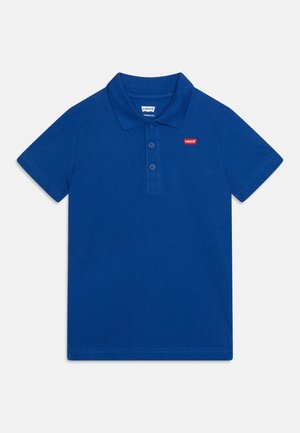 Niebieska koszulka polo z krótkim rękawem, kołnierzykiem, trzema guzikami oraz małą czerwoną naszywką z logo Levi's po lewej stronie klatki piersiowej.