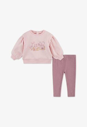 Sweatshirt rose clair avec manches bouffantes arborant le logo et le design "Levi's", associé à un legging mauve côtelé. Tenue décontractée pour enfants.
