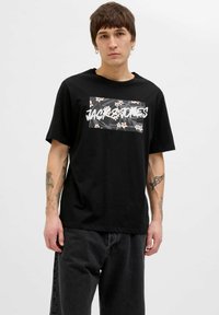 Sort bomulds t-shirt med blomster grafiktryk og hvid tekst. Korte ærmer, rund hals, afslappet pasform og subtil tekstur.