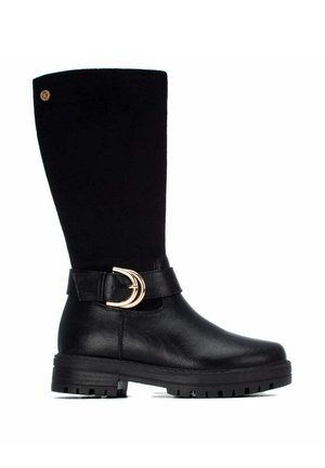 Bota negra hasta la mitad de la pantorrilla con parte inferior de cuero, parte superior de ante, detalle de hebilla dorada en el lateral y suela gruesa de goma con tacos.