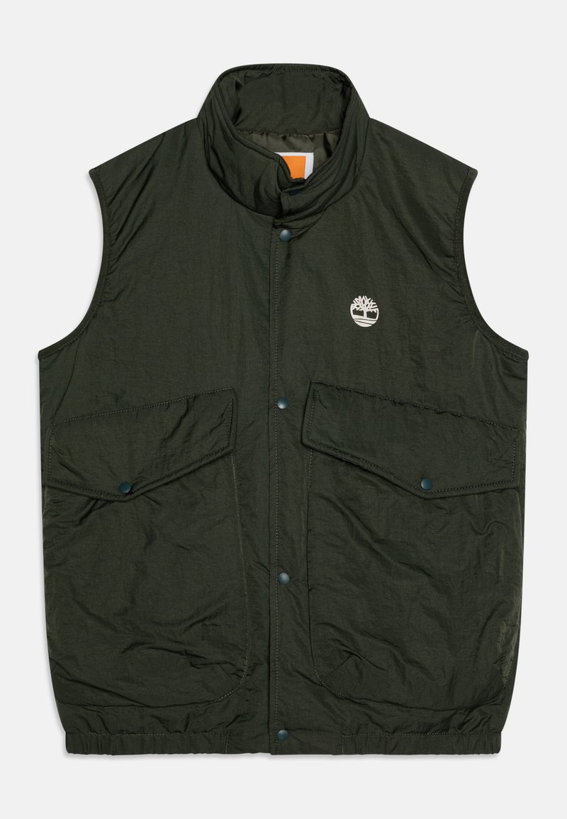 Mørkegrønn ermeløs vest med høy krage, to frontlommer og logo. Laget av lett materiale med teksturert overflate.