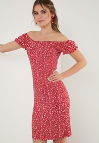 Red floral off-shoulder dress with puff sleeves, fitted design, knee-length, featuring small white flower patterns throughout.