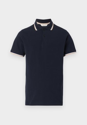 Polo de manga corta azul marino con dos botones negros y rayas beige y blancas en el cuello y los bordes de las mangas.