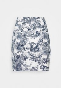 Vit kjol med intrikat tryck av en marinblå skogsscen som visar djur och träd. Figursydd design med en slät textur och mittlängd.