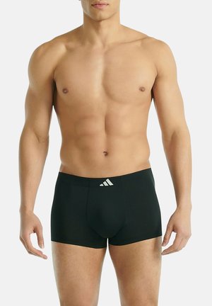 Schwarze Boxershorts aus glattem Stoff mit enger Passform, kurzen Beinen und weißem Adidas-Logo am Bund.