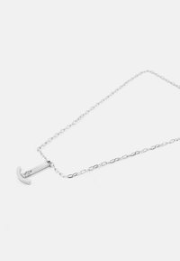 Silver chain necklace featuring a vertical anchor pendant with a smooth texture and minimalist design, displaying a subtle engraved logo.