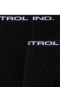 Černé boxerky s širokým elastickým pasem s nápisem "CONTROL IND." v bílém, vyrobené z hladkého materiálu a s kontrastními švy.