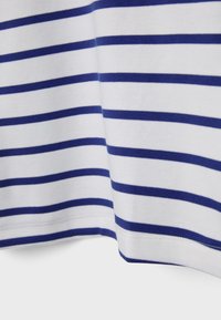 Valkoinen kangas, jossa on tasaisesti sijoitetut vaakasuorat tummansiniset raidat ja näkyvä ommel alareunassa.