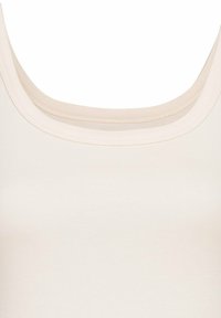 Light beige tank top featuring a scoop neckline and smooth texture. The fabric is stretchy and seamless, ideal for layering.