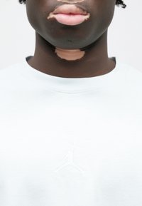 Μαλακή μπλε φούτερ με στρογγυλή λαιμόκοψη. Διαθέτει ανάγλυφο λευκό λογότυπο Jumpman και κείμενο "AIR" στο στήθος, κατασκευασμένο από μαλακό ύφασμα.