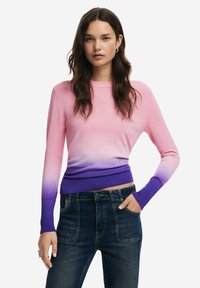 Kerge kudumiga sviiter roosast lillani, täpselt keha. Ümmargune kaelus, pikad varrukad ribaga randmete juures, kantud tumehallide teksadega.