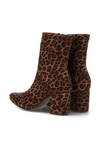 Botines de piel de leopardo hechos de material suave, con punta afilada y tacón grueso de textura lisa.