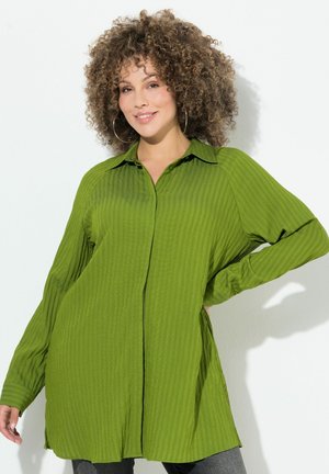 Camicetta verde a costine con chiusura a bottoni, colletto classico e maniche lunghe, caratterizzata da spacco laterale per una vestibilità comoda.
