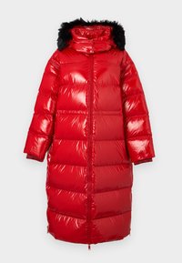 Piros, fényes pufi kabát kapucnival, amely hamis szőrmével díszített, hosszú ujjú és gumírozott mandzsettás. Teljes hosszúságú cipzárral és steppelt mintázattal rendelkezik.