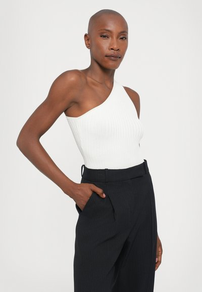 White ribbed bodysuit with one shoulder strap paired with black pinstriped trousers featuring side pockets and a tailored fit.