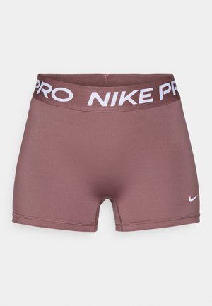 Nike Pro shorts vaaleanpunaisesta elastaanista, joissa on valkoinen joustava vyötärönauha, jossa lukee "NIKE PRO" ja pieni valkoinen logo sivussa.