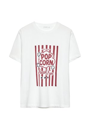T-shirt blanc à manches courtes avec un graphique de seau de pop-corn rouge et blanc, portant le texte "CRISPY DREAMS POPCORN Frais & Amusant."