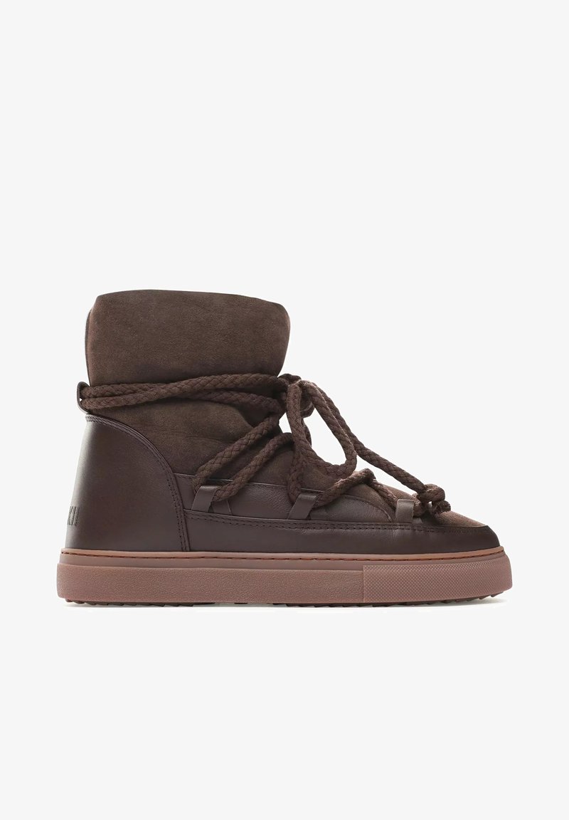 Sneaker high-top in pelle marrone con tomaia in suede, lacci spessi e suola in gomma texture. Presenta un colletto imbottito e dettagli cuciti.