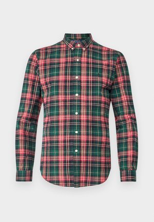 Cămașă verde în carouri cu accente roșii și bleumarin. Are mâneci lungi, guler ascuțit și cinci butoane frontale. Material din bumbac.