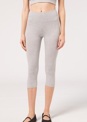 Leggings capri grises con una cinturilla alta y una textura suave, fabricados con una tela elástica para mayor comodidad. Terminan justo debajo de la rodilla.