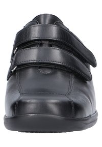 Schwarze Lederschuhe mit zwei Klettverschlüssen. Abgerundete Zehen, glatte Textur und eine robuste Gummisohle. Minimalistisches Design ohne Muster.