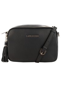 Borsa a tracolla in pelle nera con chiusura a zip, tracolla removibile e un nastro decorativo. Presenta un dettaglio del logo metallico.