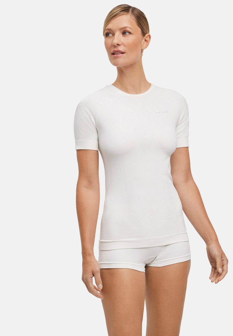 White short-sleeved athletic top with fitted design and ribbed texture. Features subtle branding, paired with matching white shorts.