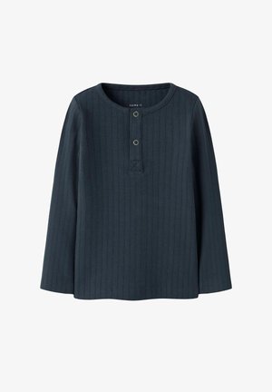 Donkerblauwe geribbelde langemouwen top met een ronde halslijn, een voorpand met twee metalen knopen, en een rechte zoom.