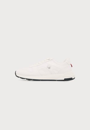 Λευκό χαμηλό sneaker με μαύρη σόλα, επάνω μέρος από δίχτυ και δέρμα, και λογότυπο "HUGO" στο πλάι.
