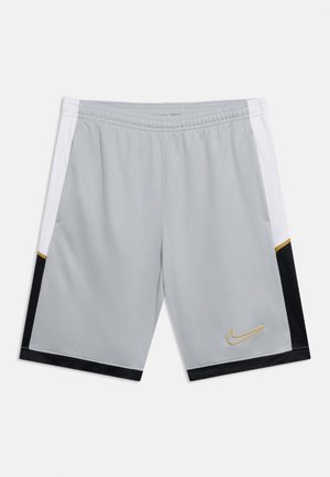 Lys grå treningsshorts med hvite og svarte sidepaneler og en liten gullfarget Nike-swoosh på fronten av høyre ben.