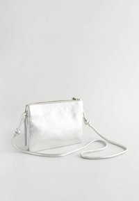Stříbrná kožená crossbody taška s hladkou texturou, obdélníkovým tvarem, zipovým uzavřením a nastavitelným popruhem se zkroucenými akcenty.