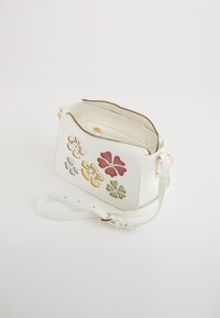 Geantă crossbody din piele albă, cu aplicații florale multicolore, accesorii din aur și un închizător cu fermoar. Curea ajustabilă pentru confort.