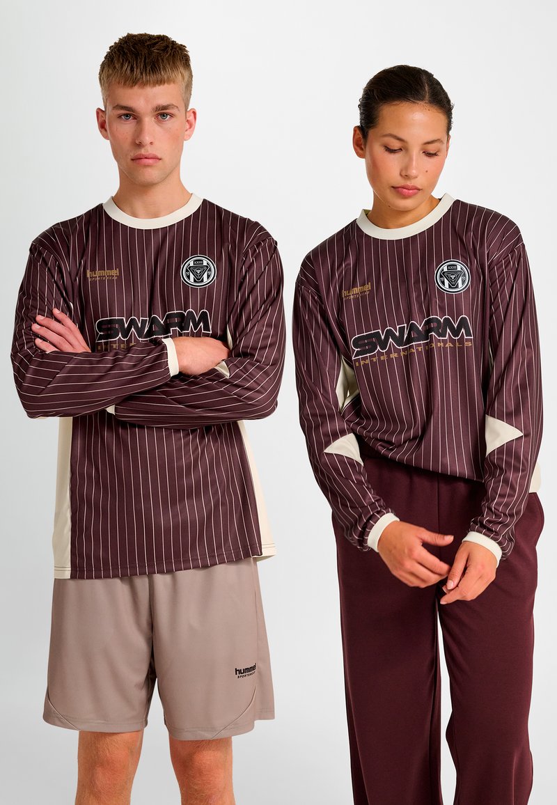 Langärmelige bordeauxrote gestreifte Trikots mit cremefarbenen Akzenten und einem Logo, kombiniert mit beigen Shorts. Glatter Stoff mit sportlicher Passform.