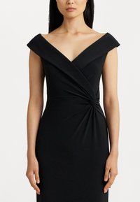 Schwarzes schulterfreies Kleid mit tiefem V-Ausschnitt und verdrehten Details an der Taille. Hergestellt aus glattem, dehnbarem Stoff. Figurbetonter Schnitt.