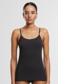 Black fitted tank top with thin straps, made of soft fabric. Features a rounded neckline and a seamless design for a smooth silhouette.