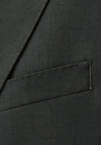 Dark green fabric of a suit with a stitched, angled flap pocket. The texture is smooth with a subtle sheen and fine weaving.