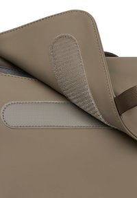Beige schoudertas met een textuur flap, klittenbandsluiting en een gladde body. Heeft een stoffen band en gestikte details.