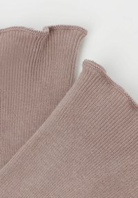 Ribbet knæhøje sokker i dæmpet mauve med en bølget kant. Teksturen er blød med et fint strikket mønster.