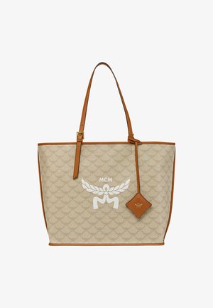 Borsa tote beige con rifiniture in pelle, caratterizzata da un motivo testurizzato, hardware dorato e un logo bianco. Spallacci regolabili marroni e dettaglio con charm.