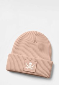 Pink ribbed beanie with fold-over cuff features a square white patch with a skull and crossbones graphic. Soft, textured fabric.