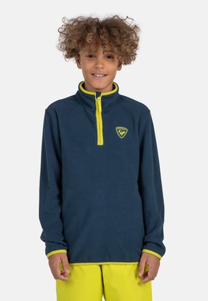 Sudadera de forro polar azul marino con media cremallera y acentos en amarillo brillante. Presenta un logo en el pecho y puños en contraste. El suéter tiene una textura suave.