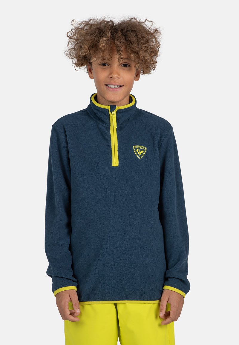 Pullover in pile blu navy con zip a un quarto e accenti giallo brillante. Presenta un logo sul petto e polsini a contrasto. Il maglione ha una consistenza morbida.