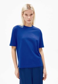 T-shirt en coton bleu avec une coupe décontractée, manches courtes et col rond. Présente un logo subtil sur le côté gauche de la poitrine.