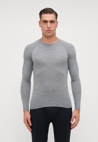 Dlouhý rukáv sportovního topu v šedé barvě s jemn�ým proužkovaným vzorem, vyrobený z elastického materiálu. Má kulatý výstřih a přiléhavý střih.